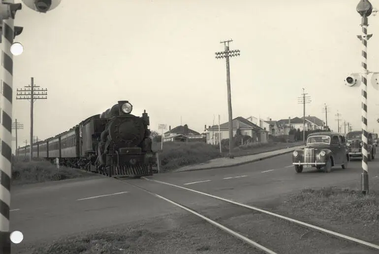 Image: Steam locomotive WAB 769 and passenger train at level crossing, 1954