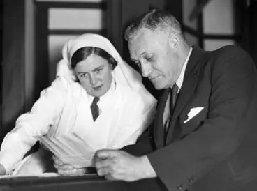 Image: Captain Frederick Harold Batten and an unidentified dental nurse reading a telegram of congratulations for Jean Batten's progress on her England - New Zealand flight