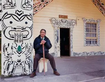 Image: Pukerau Rangitutia in front of Hoturoa Whare Whakairo of Aotearoa Marae, Wharepuhanga, Sept 1990