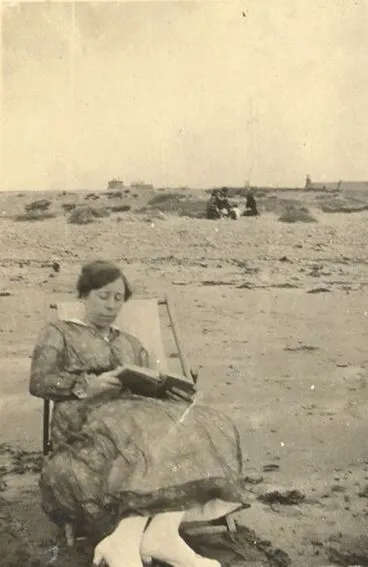 Image: Lady reading a book at the beach