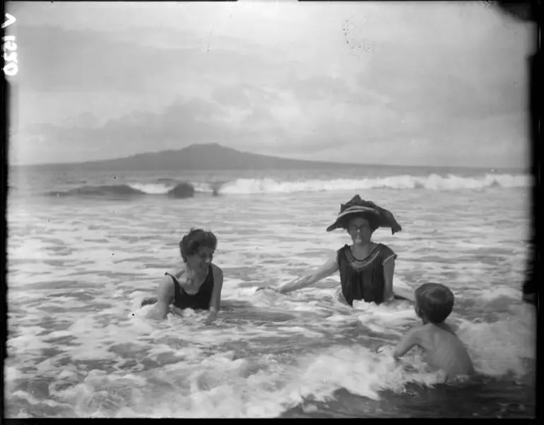 Image: Two women and a boy in the waves, Auckland