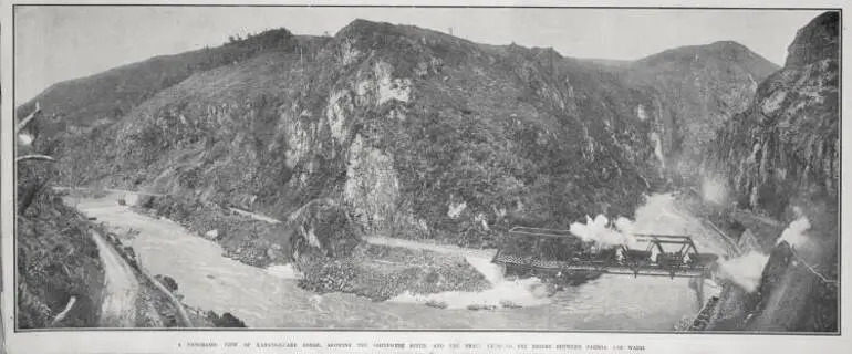 Image: A PANORAMIC VIEW OF KARANGAHAKE GORGE, SHOWING THE OHINEMURI RIVER, AND THE TRAIN CROSSING THE BRIDGE BETWEEN PAEROA AND WAIHI