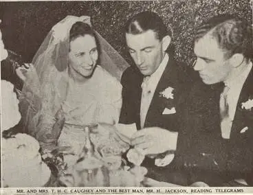 Image: Mr. and Mrs. T. H. C. Caughey and the best man, Mr. H. Jackson, reading telegrams
