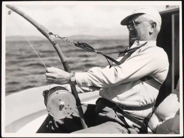Image: A man playing a striped marlin on board the launch 'Ozone'