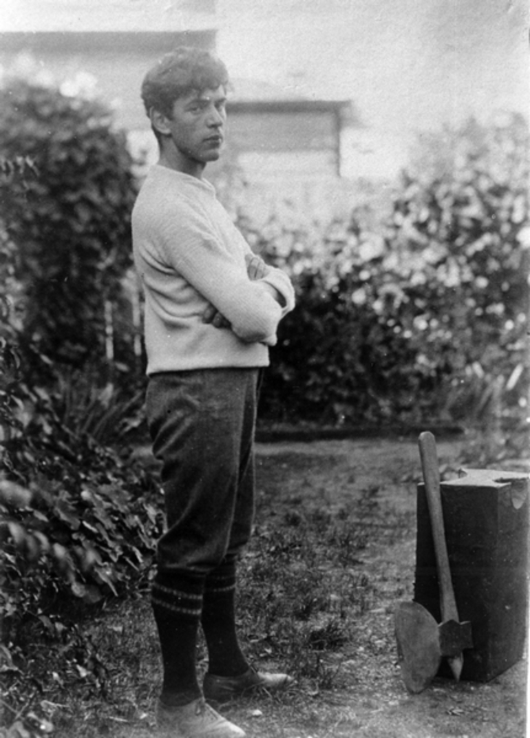 Image: A man standing in the garden with an executioner's block and axe