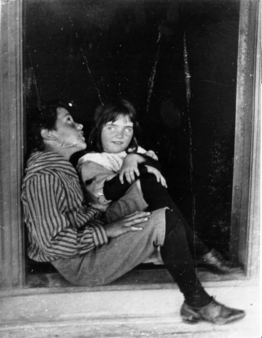 Image: A boy and a girl sitting in a doorway