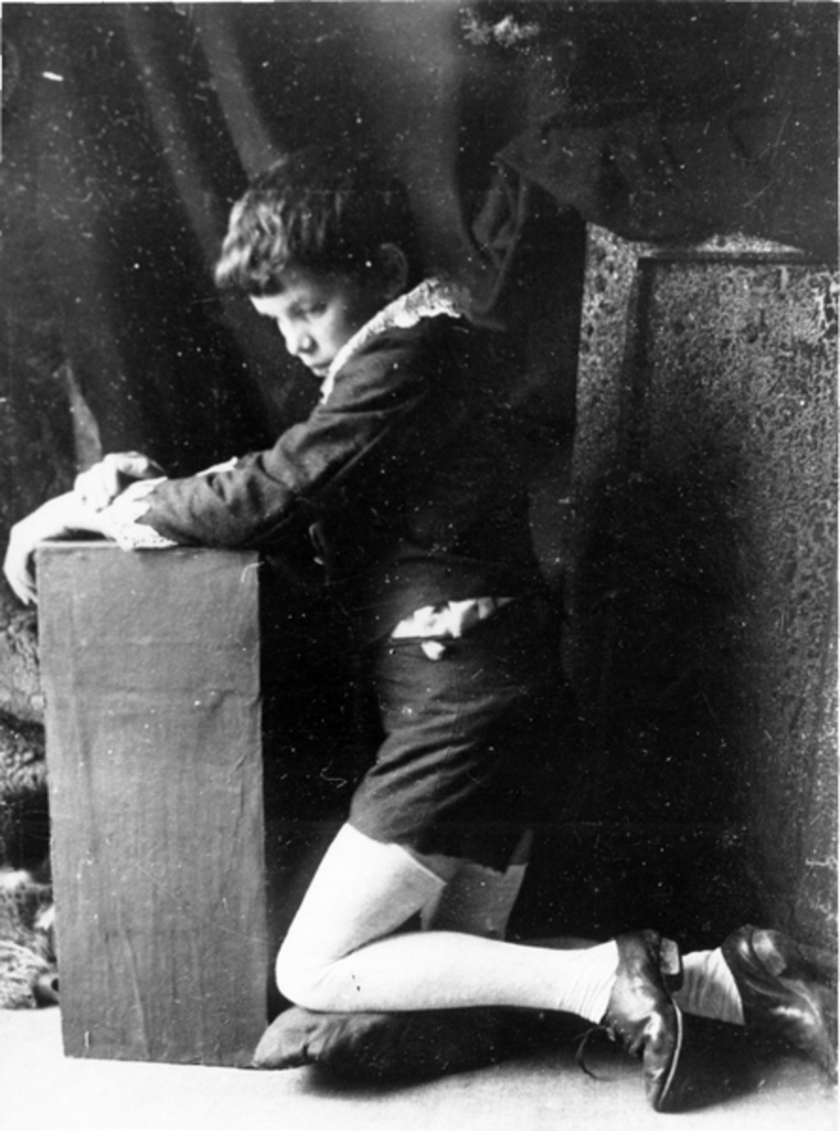 Image: A boy kneeling onto a pillow