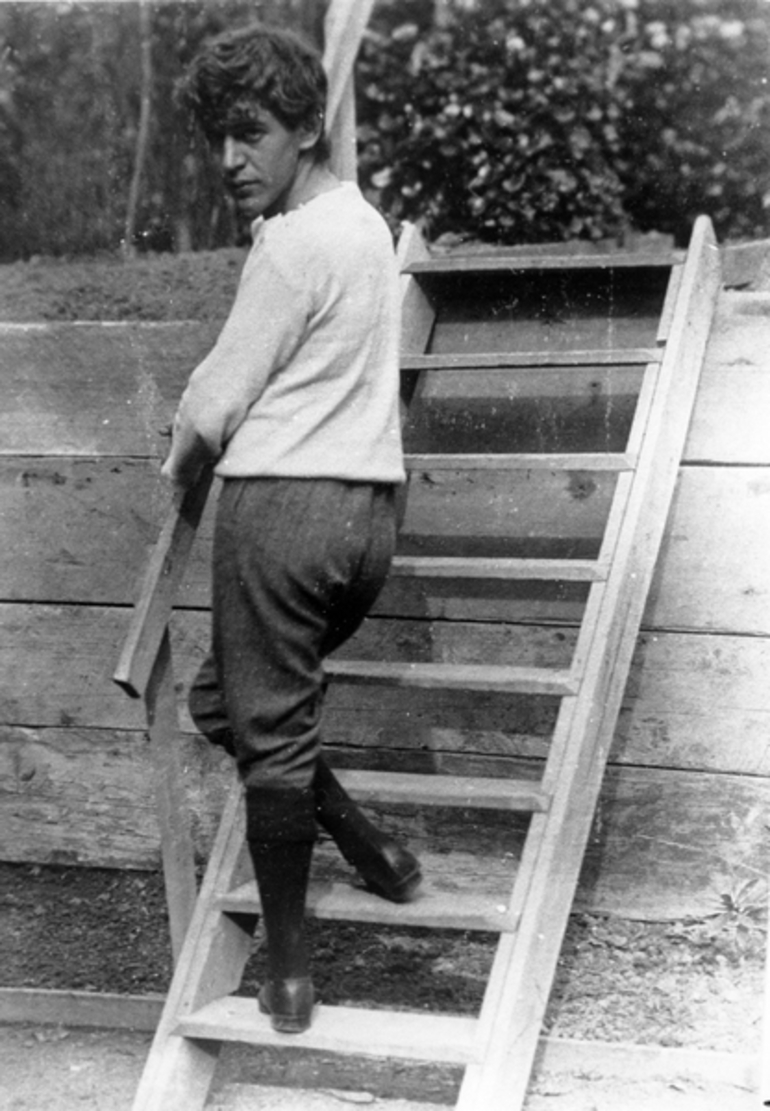 Image: A theatrical scene of a man walking up a set of stairs