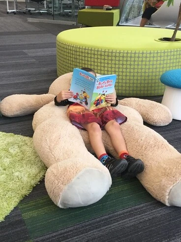 Image: Child reading with teddy bear 2