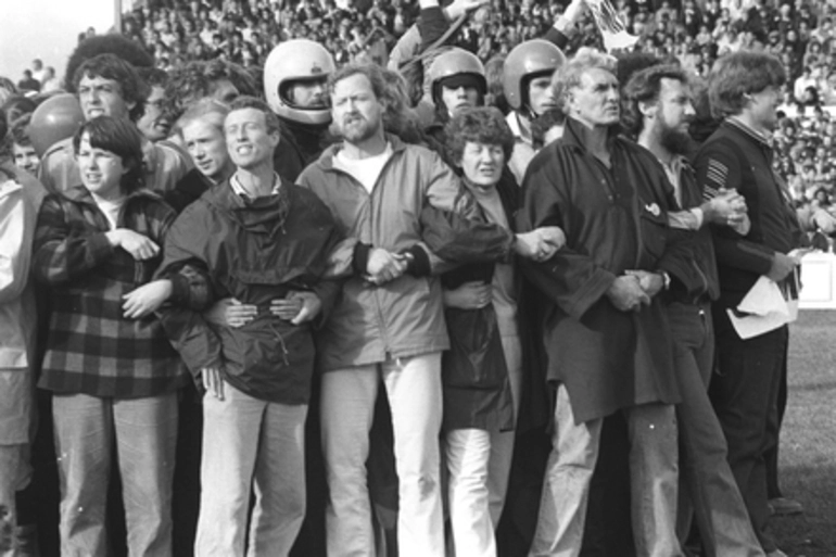 Image: Group of protestors middle of rugby field with spectators behind. Anti Springbok Tour protest march, Hamilton