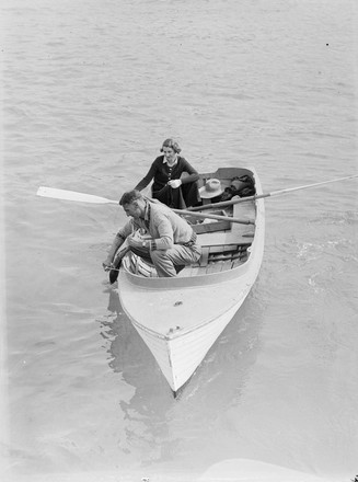 Image: [A woman and a man fishing in a dinghy]