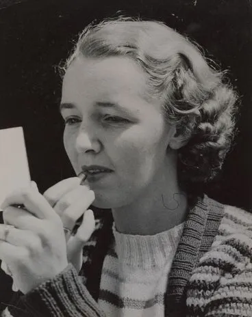 Image: Portrait of a young woman applying lipstick