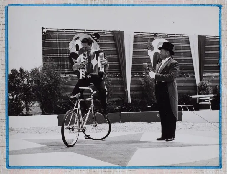 Image: [man on bike playing accordion]