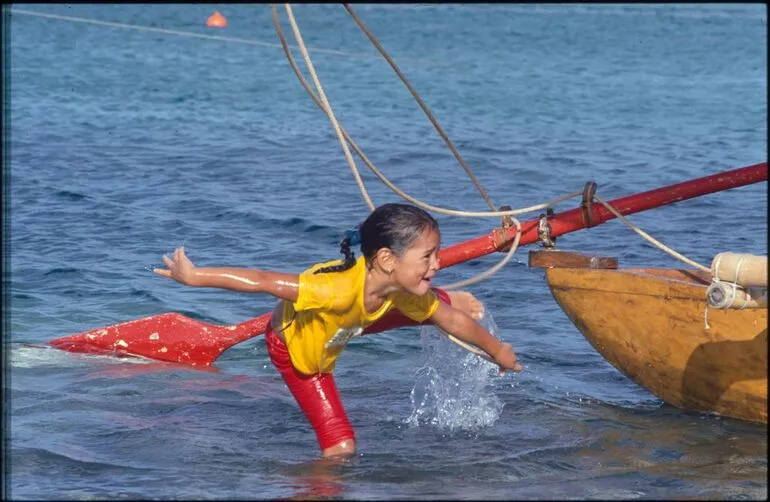 Image: Child playing in water, with boat