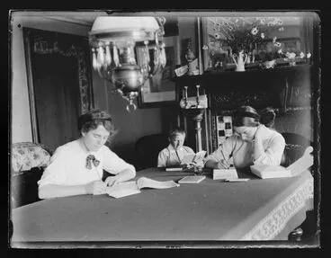 Image: Dora, Clif and Marjorie Adkin writing and reading