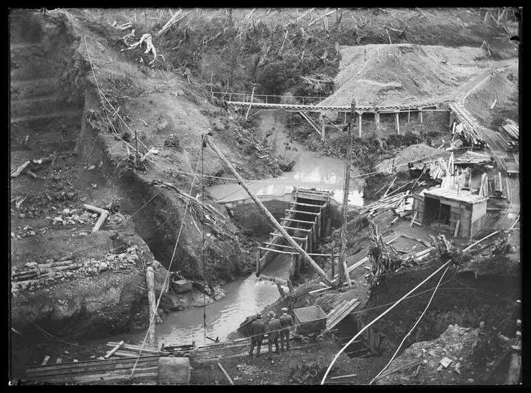 Image: Tokomaru River at dam site showing auxiliary dam and flume which when completed will facilitate the placing of the concrete foundations of the big dam in the stream bed