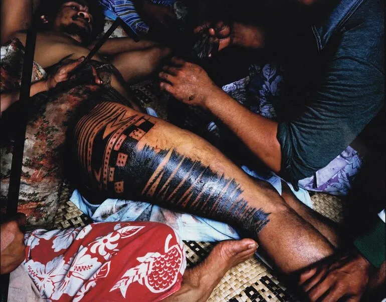 Image: 1982. Farwood Drive, Henderson, west Auckland. Tattooing Uli. Tufuga tatatau: Su'a Tavui Pasina Iosefo Ah Ken