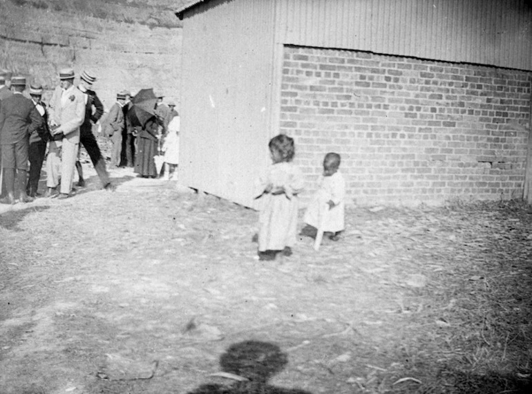 Image: Photographer unknown :[Children at Orakei Marae, Bastion Point, Auckland, ca 1890, with a group of Pakeha visitors, probably on the occasion of the racing of Paora Tuhaere's canoe]