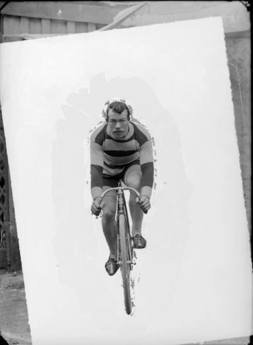 Image: Outdoors unidentified portrait of man with moustache on racing road bicycle in woollen striped clothing and shoes, probably Christchurch region