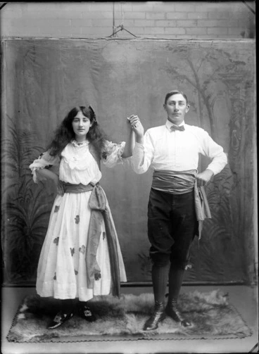Image: Portrait of unidentified man and woman in dance costume, with painted studio backdrop, probably Christchurch district