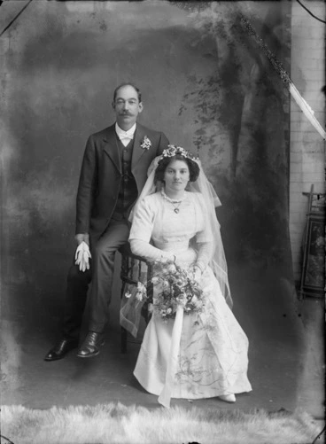 Image: Unidentified wedding couple, with a painted studio backdrop, probably Christchurch district