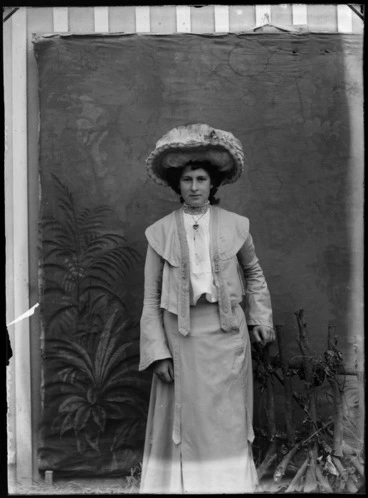Image: Portrait of unidentified woman wearing a hat, with a painted studio backdrop, probably Christchurch district
