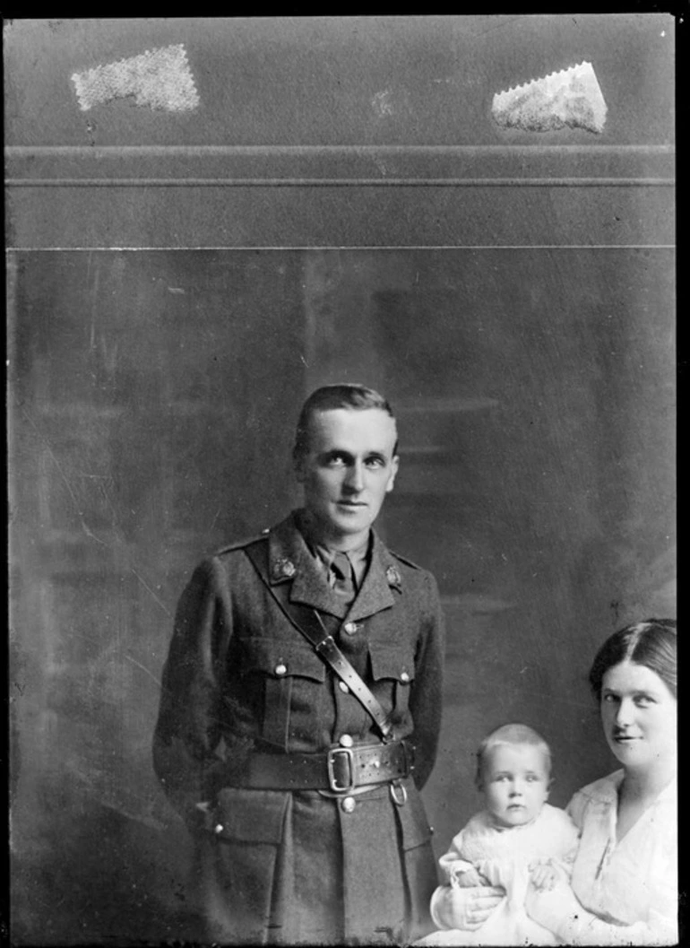 Image: Unidentified family portrait within home, a World War I soldier with collar badges with shoulder and waist belts, wife and baby, probably Christchurch region