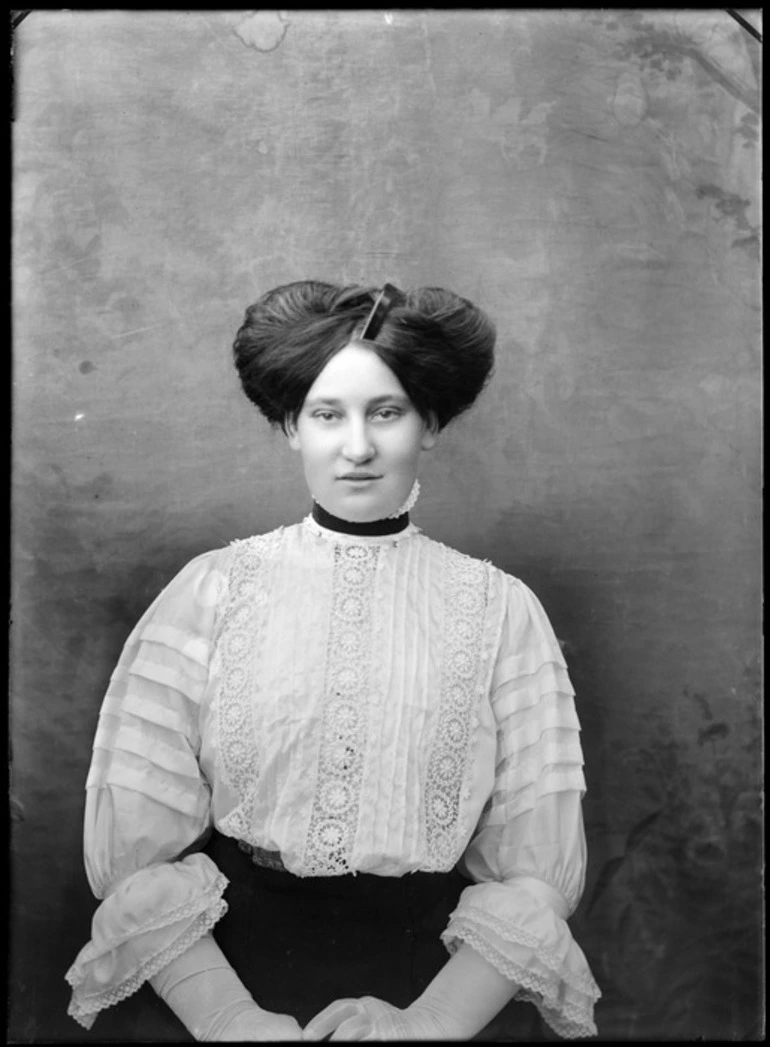 Image: Studio portrait of an unidentified woman, wearing a high-necked lace blouse and a pompadour hairstyle, possibly Christchurch district