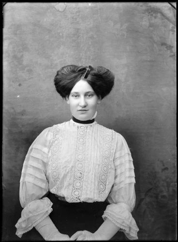 Image: Studio portrait of an unidentified woman, wearing a high-necked lace blouse and a pompadour hairstyle, possibly Christchurch district