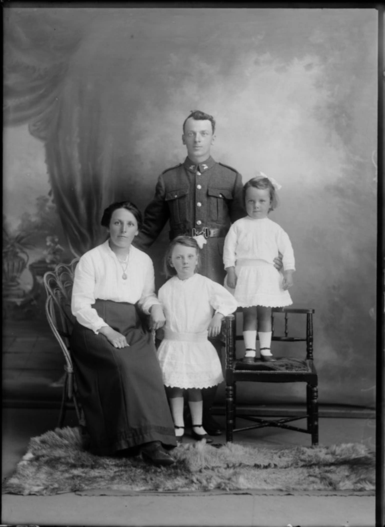 Image: Studio unidentified family portrait, a World War I soldier with [Tui or Huia?] collar badges and wife with portrait necklace, alongside young daughters, Christchurch