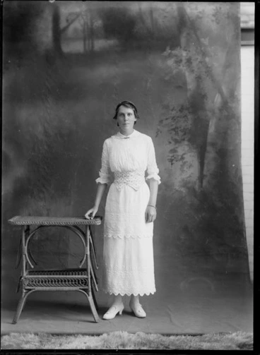 Image: Studio portrait of unidentified woman, with a painted studio backdrop, probably Christchurch district
