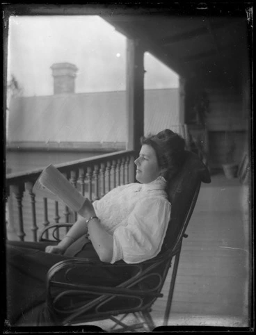 Image: Unidentified woman sitting in a chair reading a book