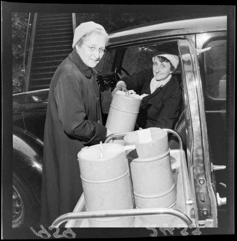 Image: Two unidentified women unloading containers of food from a car, for 'Meals on Wheels' service, Wellington