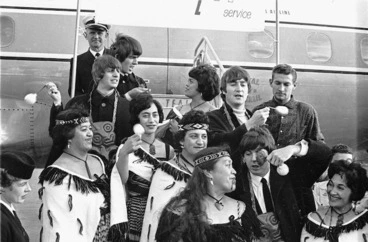 Image: The Beatles and an unidentified Maori group at Wellington Airport during their New Zealand tour