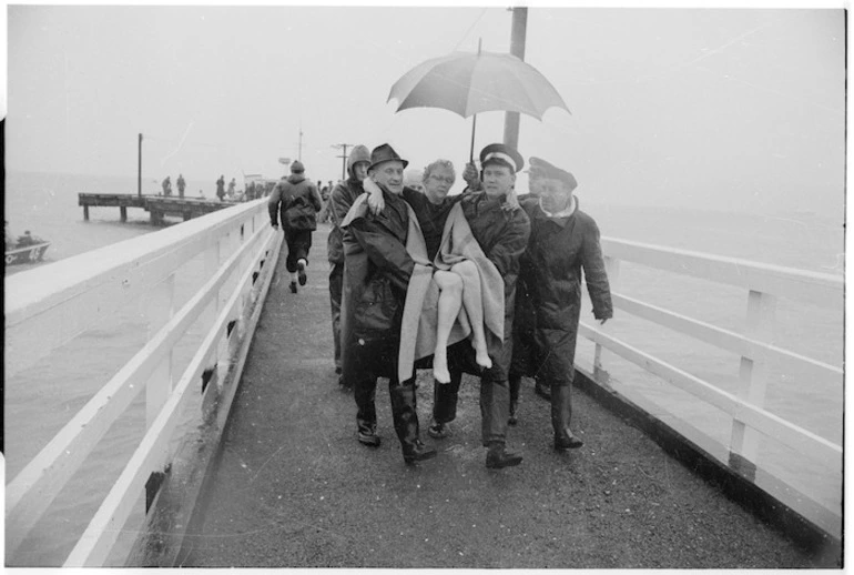 Image: Survivor from Wahine shipwreck being carried down wharf, Seatoun, Wellington