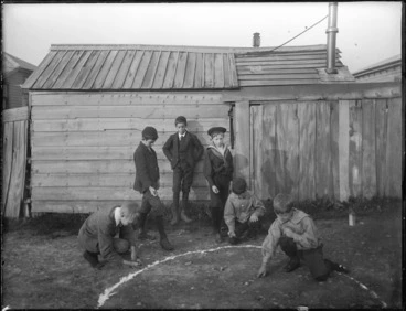 Image: Six boys playing marbles outside