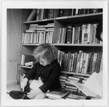 Image: Child photographed against shelves of books