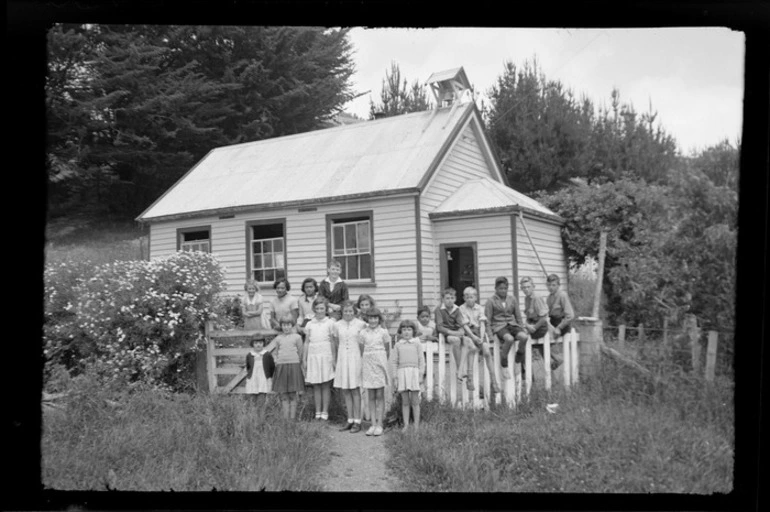 Image: Children standing outside a one classroom school, probably Banks Peninsula