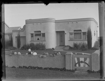 Image: Exterior of an art deco house with rabbit sculptures on the front lawn and dahlias in the garden, location unidentified