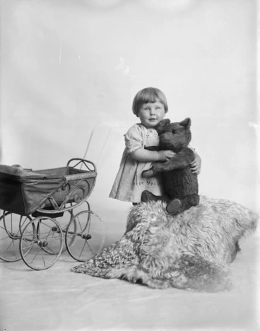 Image: Young girl with a pram and a teddy bear