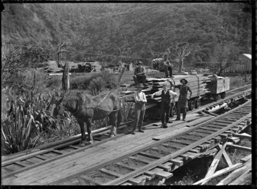 Image: Horse-drawn wagon carrying sawn timber, on the railway track of the Piha to Karekare tramway.