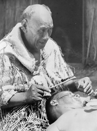 Image: Moore & Thompson (Photographers) : Man tatooing the face of another, with traditional implements
