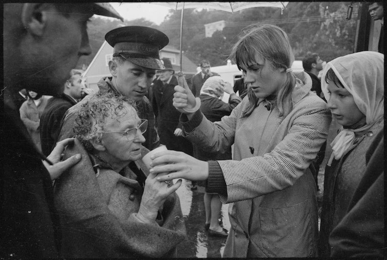 Image: Elderly female survivor from the Wahine shipwreck being served soup on Seatoun beach, helpers include Salvation Army Captain David Bennett