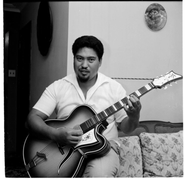 Image: Henare Gilbert singing and playing his guitar at his home in Stokes Valley