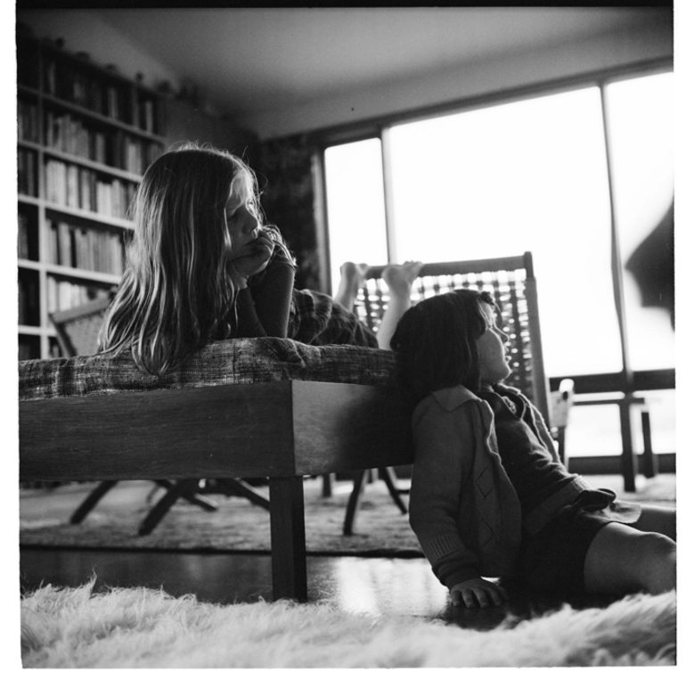 Image: Two young girls watching TV inside a house in an unidentified location