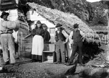Image: People standing outside a whare in Plimmerton