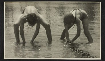 Image: Two children wearing swimming costumes in shallows