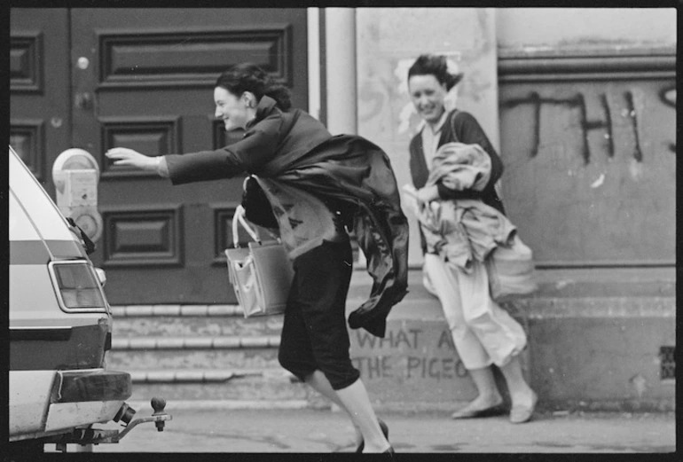 Image: Woman reaching for a parking meter as she battles gale-force north-westerly winds, Wellington - Photograph taken by Ian Mackley