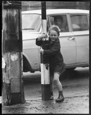 Image: Boy clinging to a pole on a windy day, Wellington