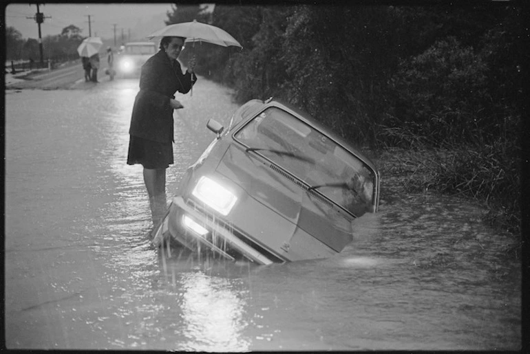 Image: Car in a flooded ditch, Main Road, Te Marua, with owner Zyla Max standing nearby - Photograph taken by Ian Mackley